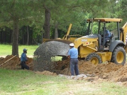Adcock Excavating crew installing a septic system with a backhoe